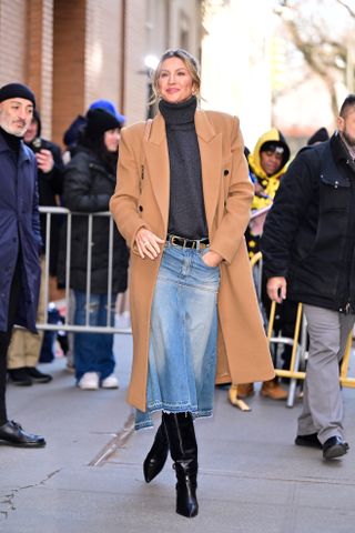 Gisele Bunchen wearing a camel coat with a denim midi skirt and black knee boots in NYC