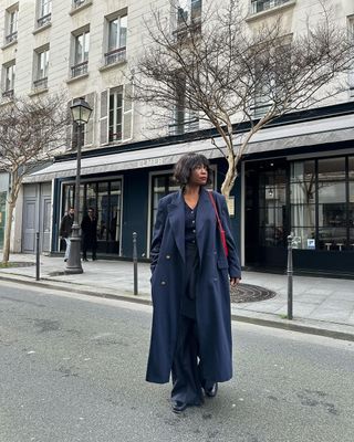 French fashion influencer @frannfyne wearing a navy coat in Paris