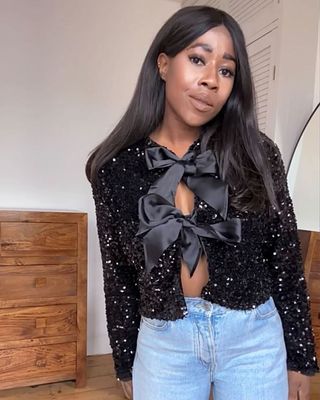 Influencer wears a bow cardigan.