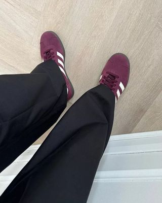 Influencer wears burgundy trainers.