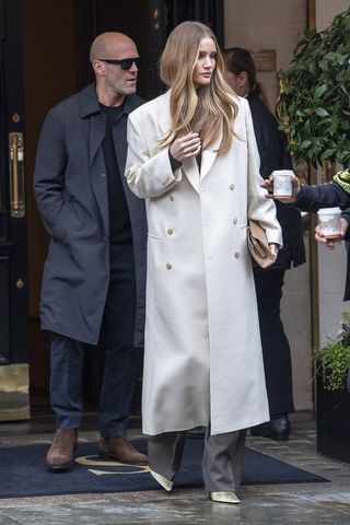 Rosie Huntington-Whiteley wearing a white dress and sparkly coat