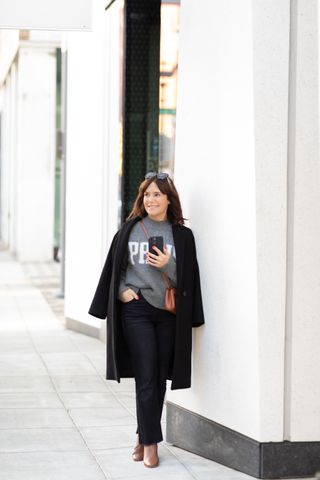 A former Nordstrom buyer wearing a long wool coat.