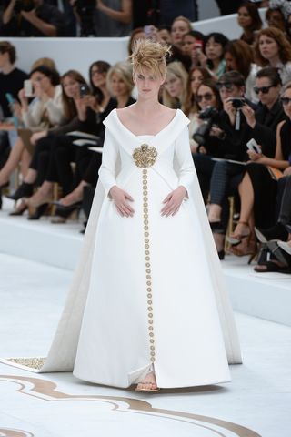 a model wears a Chanel bridal look on the runway