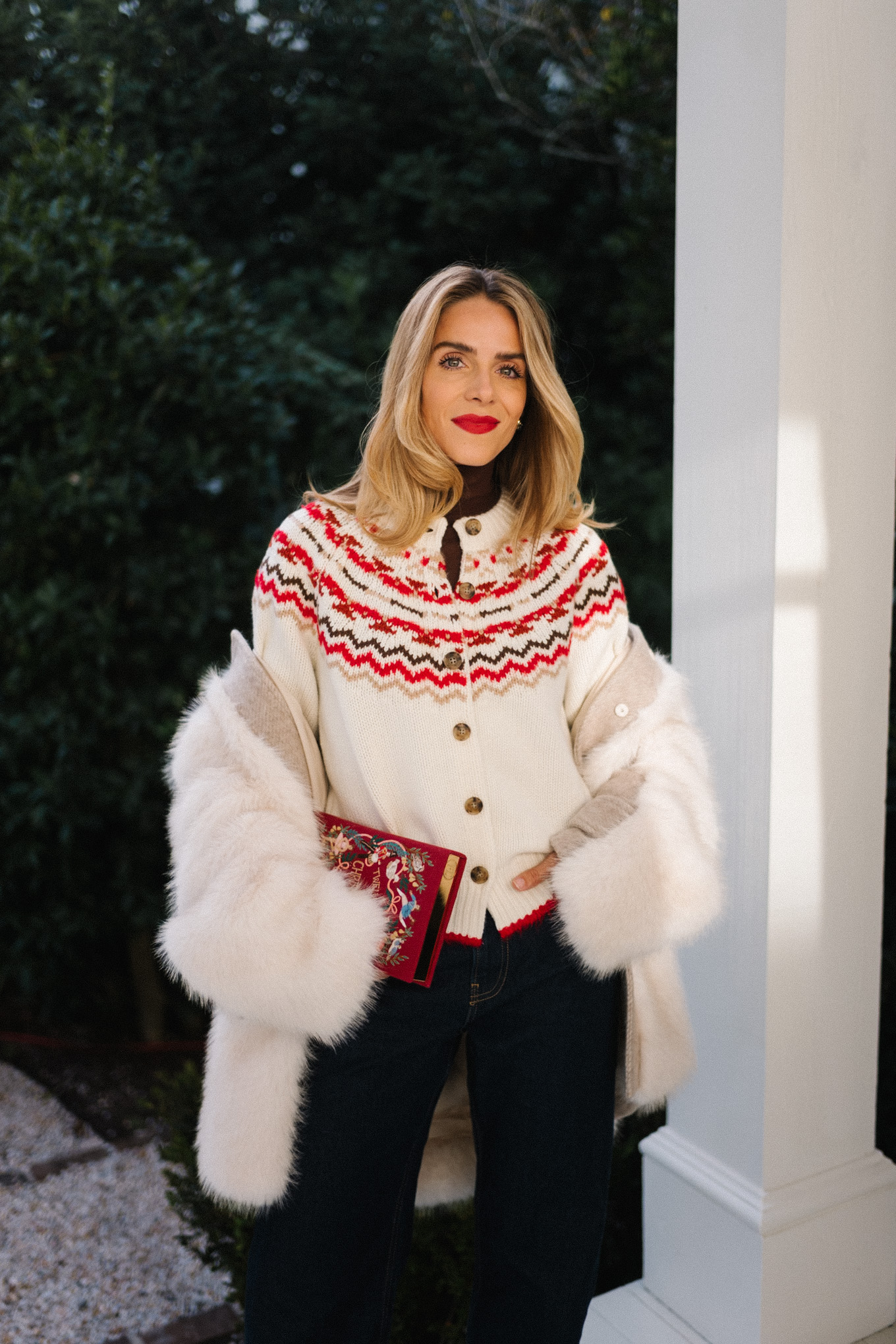 white fur coat white red fair isle cashmere cardigan dark denim red book clutch