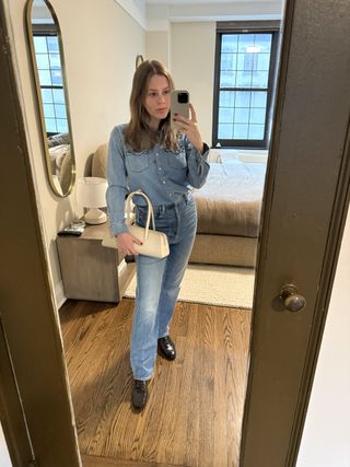 Nikki wears a denim top, jeans, a white bag, and croc loafers.