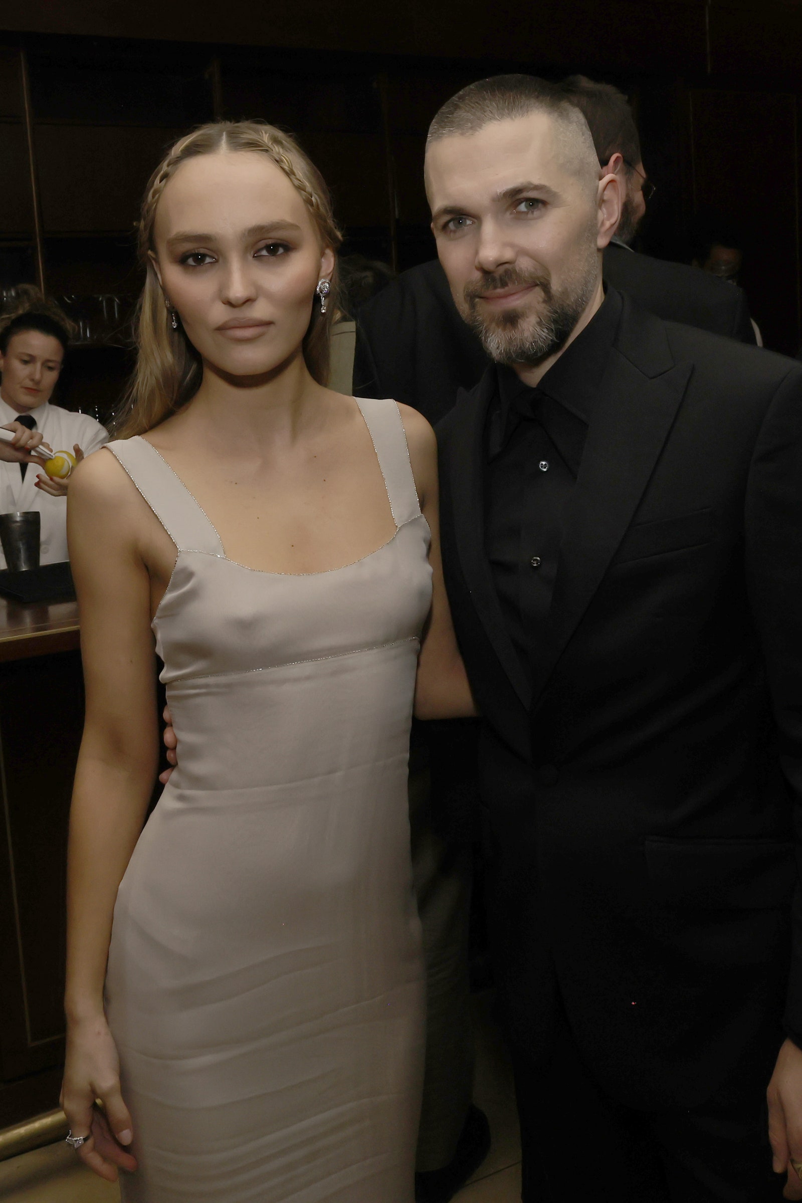 Image may contain Robert Eggers LilyRose Depp Clothing Dress Fashion Formal Wear Suit Person Photobombing and Cup