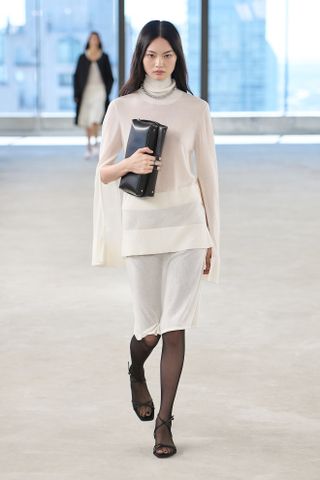 a model walks the Toteme spring/summer 2025 runway wearing a high neckline top