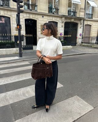 @slipintostyle wearing a cream turtleneck short-sleeve sweater with barrel-leg jeans and patent-leather Saint Laurent flats.