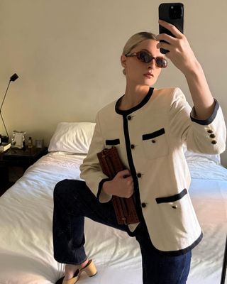 fashion influencer Christie Tyler wearing a black and white Chanel evening jacket with jeans