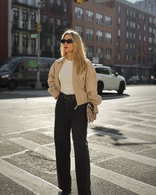 Woman wearing black wide-leg jeans on SoHo street.