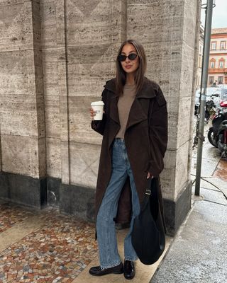 Felicia Akerstrom wearing a brown coat and Saint Laurent loafers