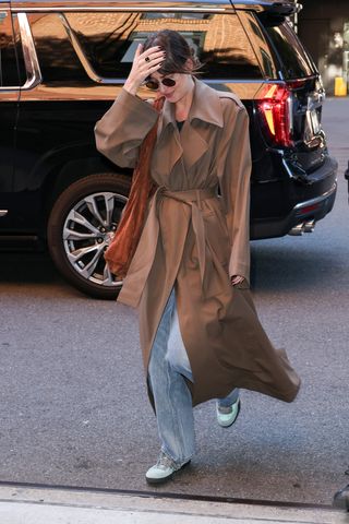 Dakota Johnson wearing brown bag and trench coat.