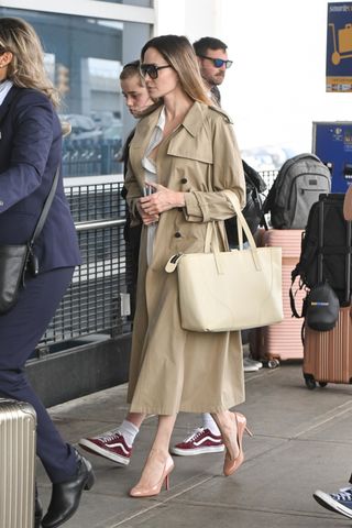 Actress Angelina Jolie in a trench coat with nude heels at JFK.