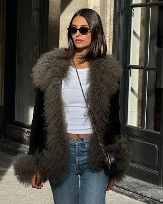 woman wearing faux fur jacket and jeans