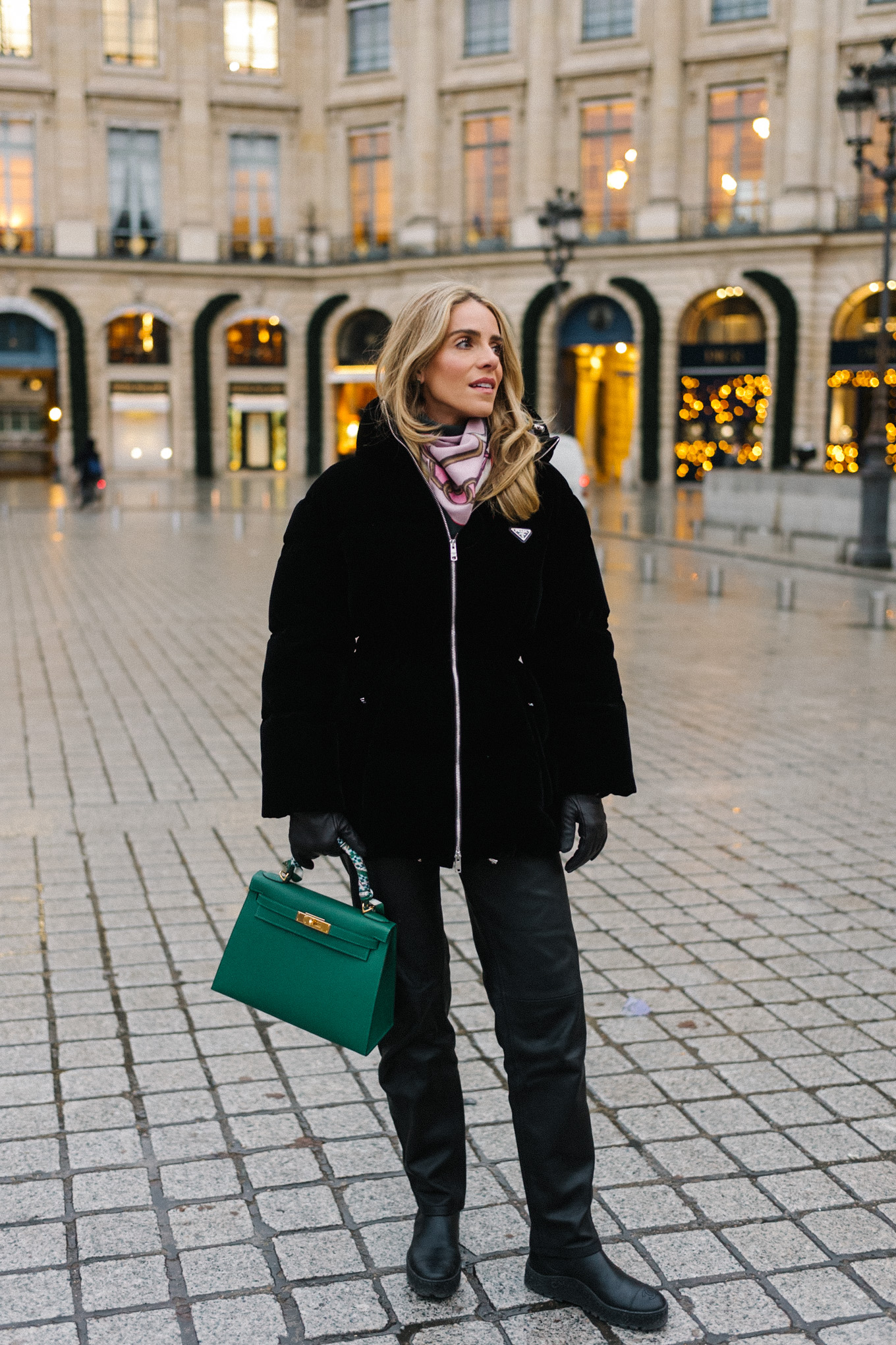 black velvet puffer coat black pants green handbag in paris