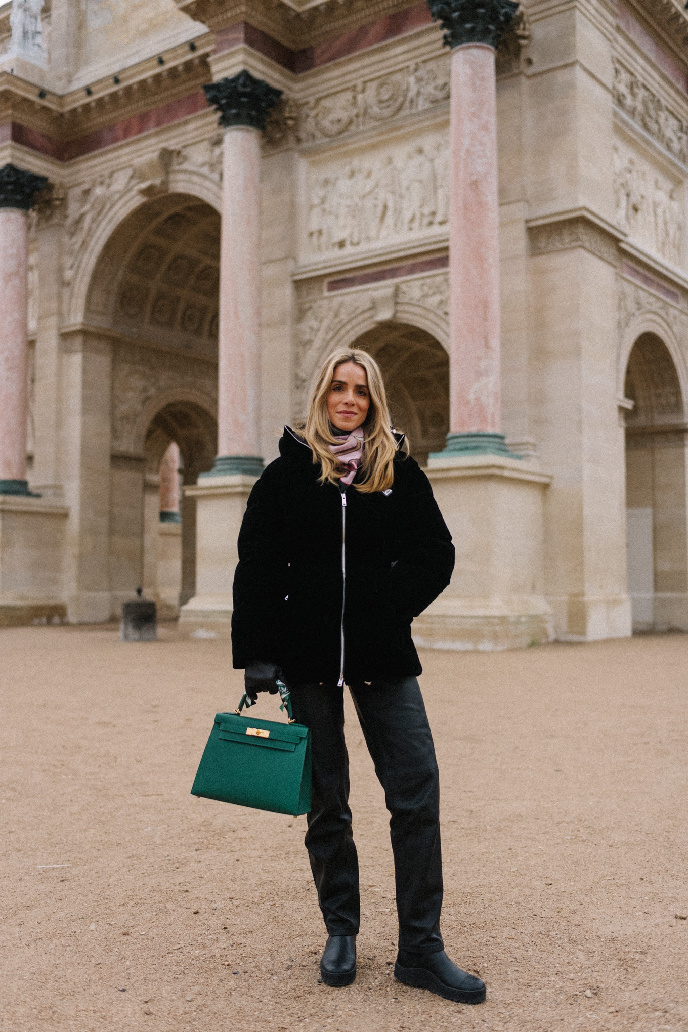 black velvet puffer coat black pants green handbag in paris