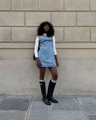 influencer in riding boots and denim dress