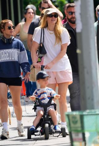 Jennifer Lawrence wears Freja Mini Chrystie Bag in black with a white T-shirt, and pink shorts.