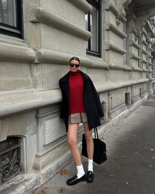 @maryljean wearing a pleated mini skirt, red jumper and loafers with socks