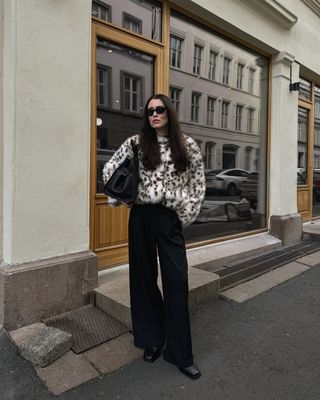 @annabelrosendahl wearing a faux fur coat, wide-leg jeans and loafers