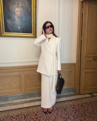 @iliridakrasniqi wearing a white blazer and skirt