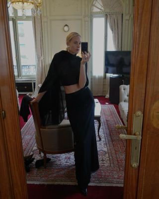 Elly McGaw wearing a black scarf-like top with a matching maxi skirt.