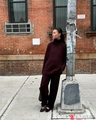 @mimixn wears an elegant winter outfit consisting of a burgundy jumper, matching trousers, and mary jane shoes