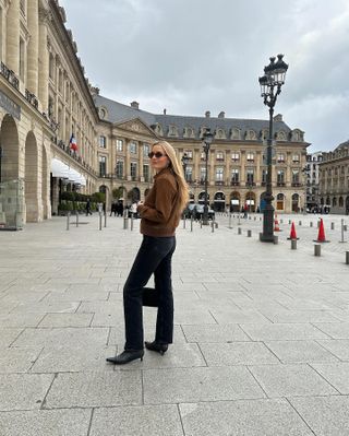 Kristen Nichols in Paris wearing a brown suede bomber jacket and black Zurie Citizens of Humanity jeans.