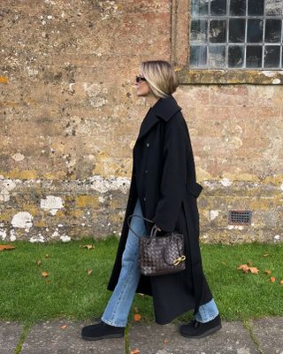 Eliza Huber wearing Clarks Wallabee shoes with a black coat, jeans, and a Bottega Veneta Andiamo bag at Babington House in England