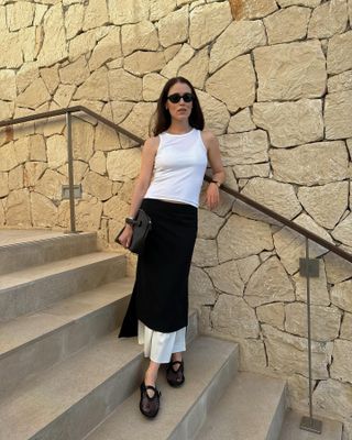 Annabel Rosendahl wearing a white tank top, black-and-white The Garment skirt; and black Alaïa net flats.