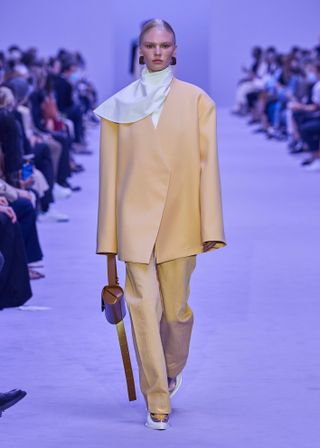 a Jil Sander model walks the spring/summer 2022 runway carrying a Cannolo bag