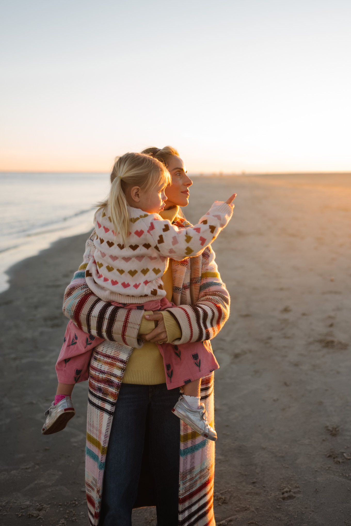 rainbow stripe coat yellow turtleneck sweater blue jeans yellow sneakera