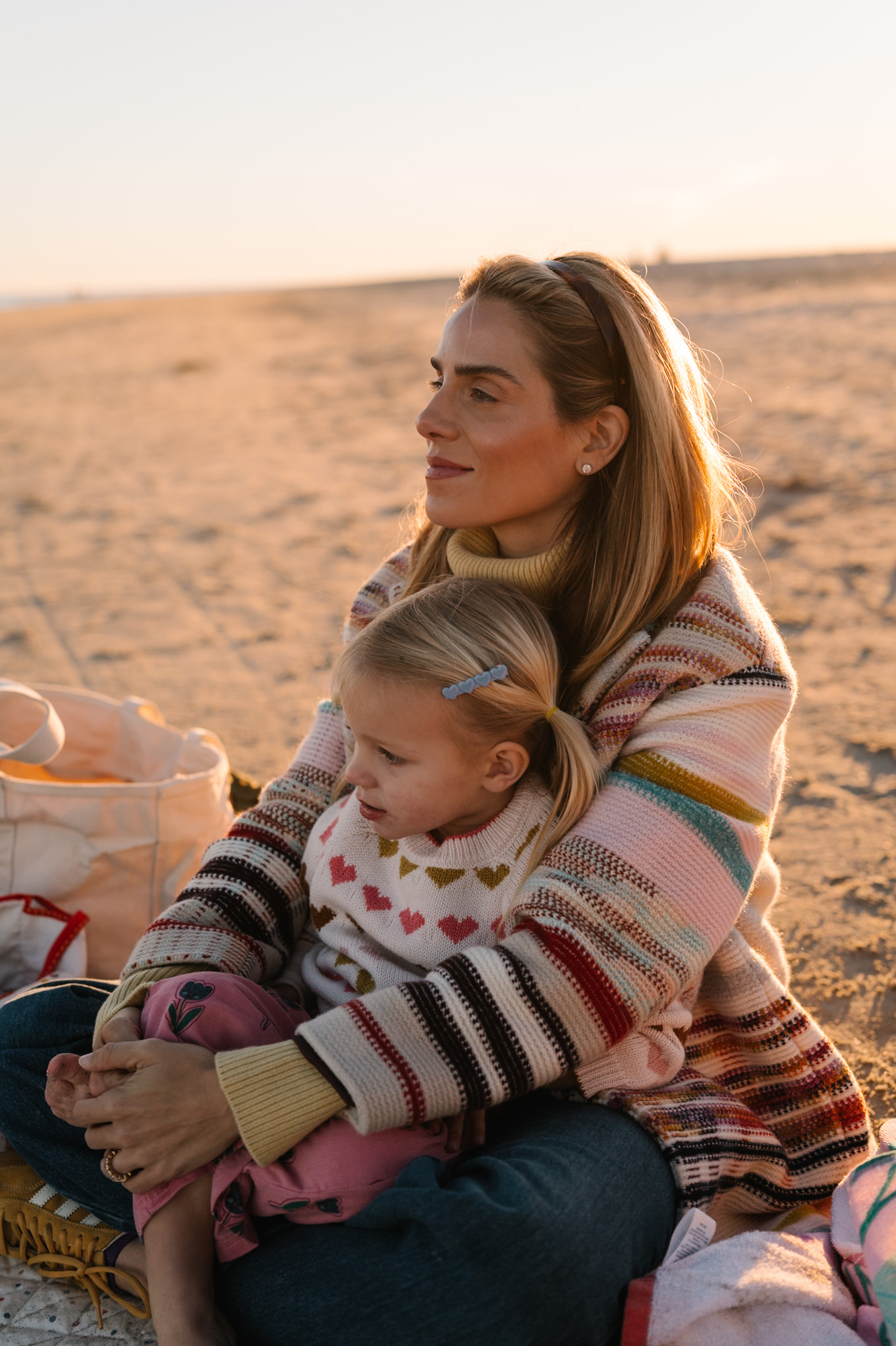 rainbow stripe coat yellow turtleneck sweater blue jeans yellow sneakera