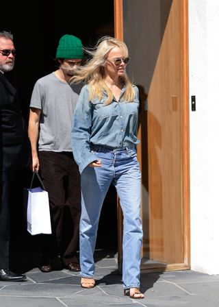 Pamela Anderson wearing jeans and high-heel sandals.