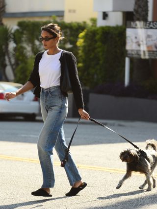 Laura Harrier wears straight-leg jeans and mules.