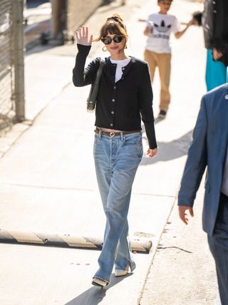 Dakota Johnson wears jeans and heels.