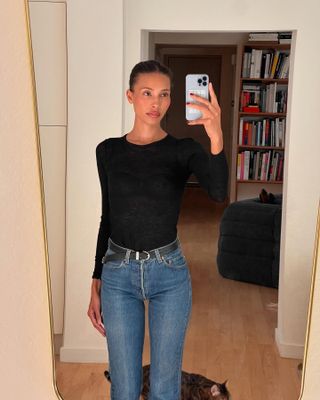 Influencer wearing a black tee and jeans