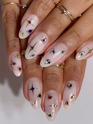 A nude pink manicure with nail gems by Imarni Nails.