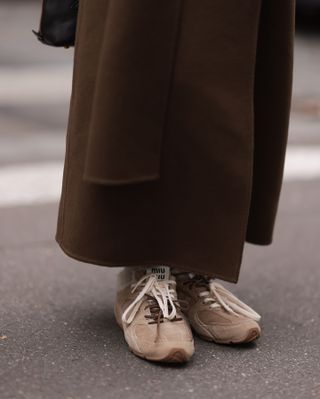 Woman wearing Miu Miu suede sneakers.