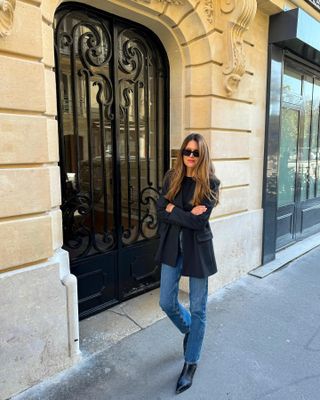 Woman in jeans and black blazer.