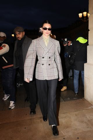 Kendall Jenner wears a blazer, black trousers and leather loafers.