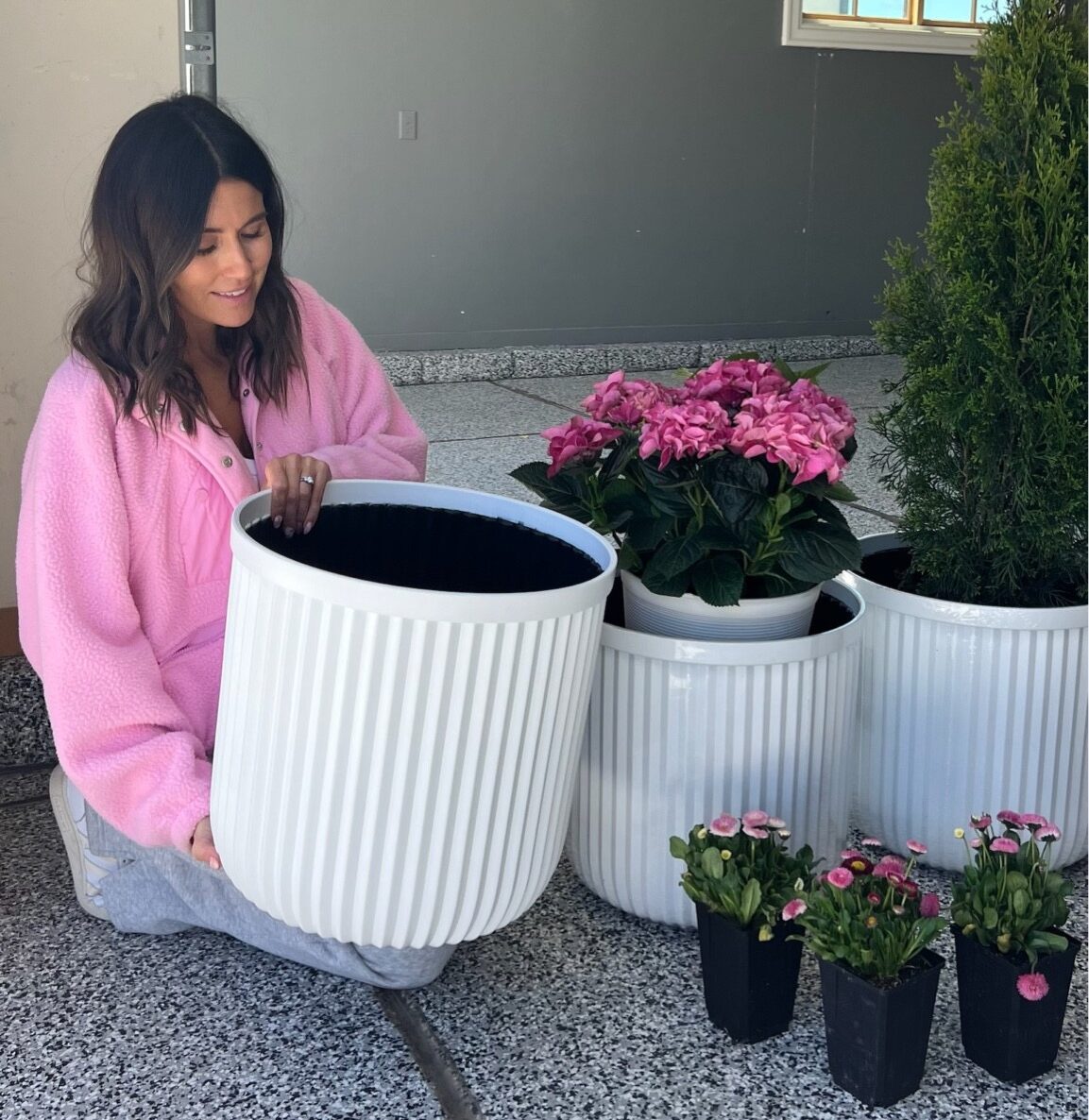 Christine Andrew planting flowers in her new white planter pots. 