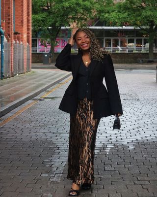 Damilola Edaowo in a blazer, vest, zebra print skirt, and heels.