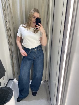 Woman wears white t-shirt and barrel-leg jeans