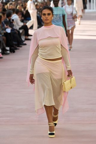 Woman in powder pink and butter yellow outfit on the Chanel runway