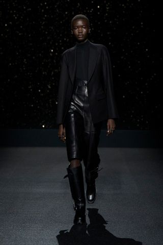 Models wears leather capri pants and a black blazer on the Hermès runway.