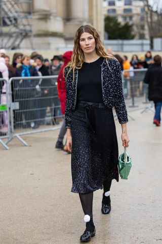 Veronika Heilbrunner wears grey jacket, two tone black grey skirt, metallic green bag outside Chanel during Haute Couture Spring-Summer 2025 as part of Paris Fashion Week on January 28, 2025 in Paris, France.