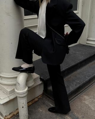 Christie Tyler wearing a suit, a silk top, socks, and patent leather Chanel moccasins.