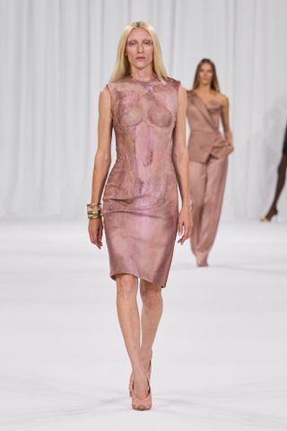 A woman at the Balmain spring/summer 2025 show wearing a pink dress and pink heels.