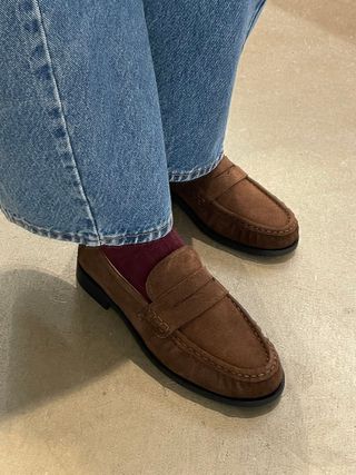 Woman wears brown suede loafers